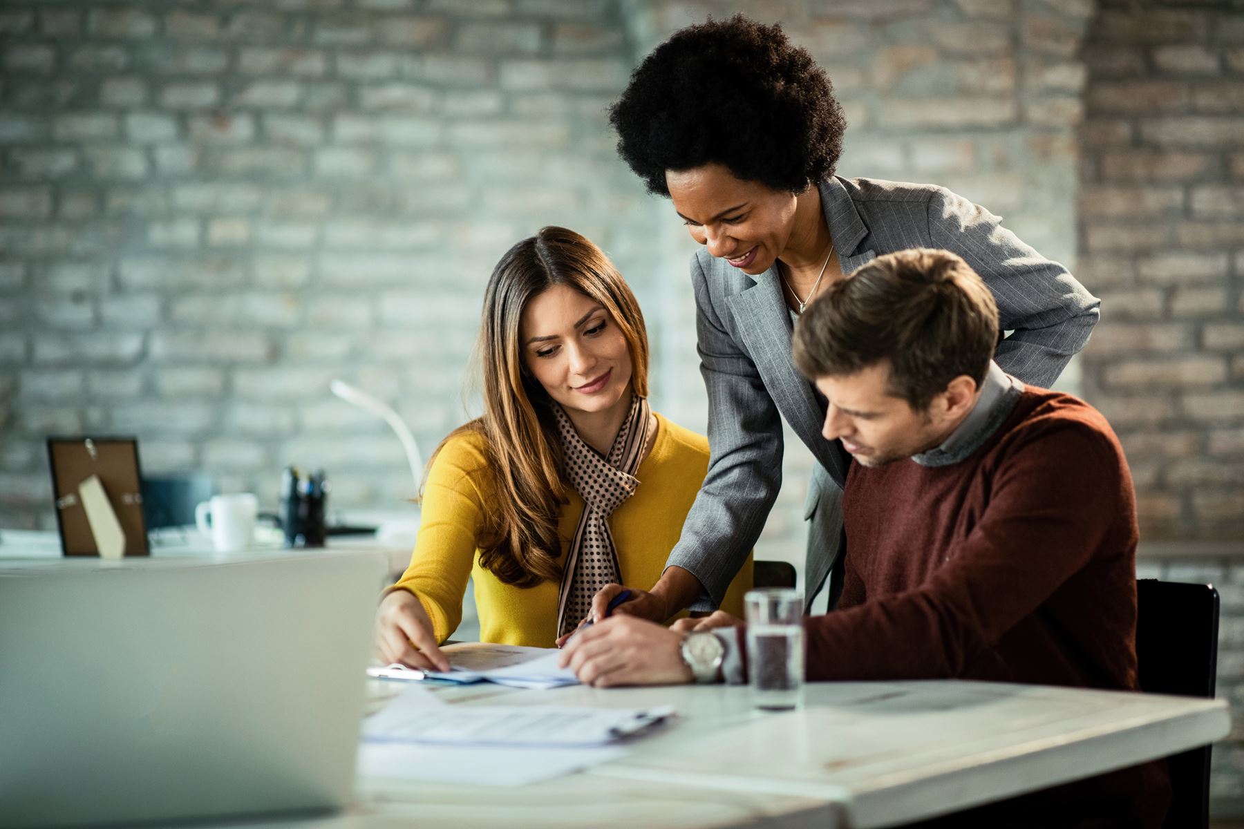 Man and woman discussing paper work with another woman